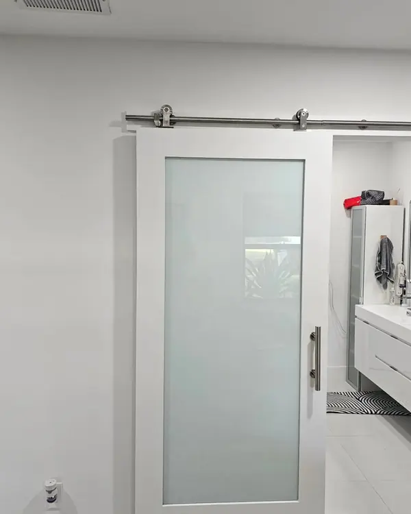 Sliding barn door with frosted glass, open to a bathroom