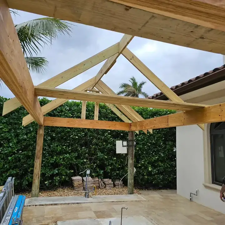 Pavilion posts, beams and first roof framing on a travertine patio