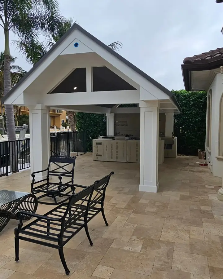 Finished pavilion with white columns over travertine pavers