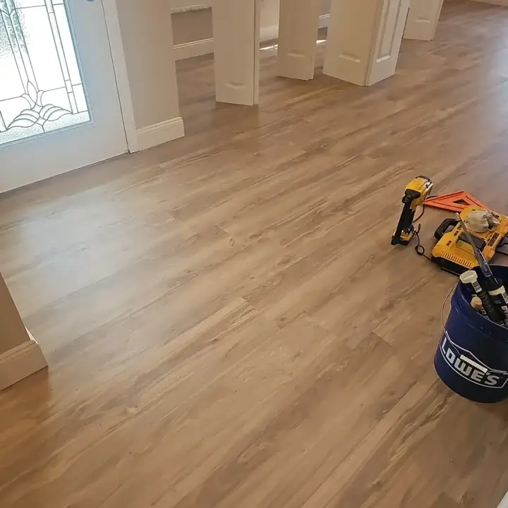 New plank floor running through a doorway, with tools on it