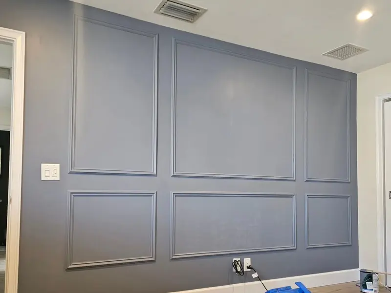 The same wall molding painted as a blue-grey accent wall