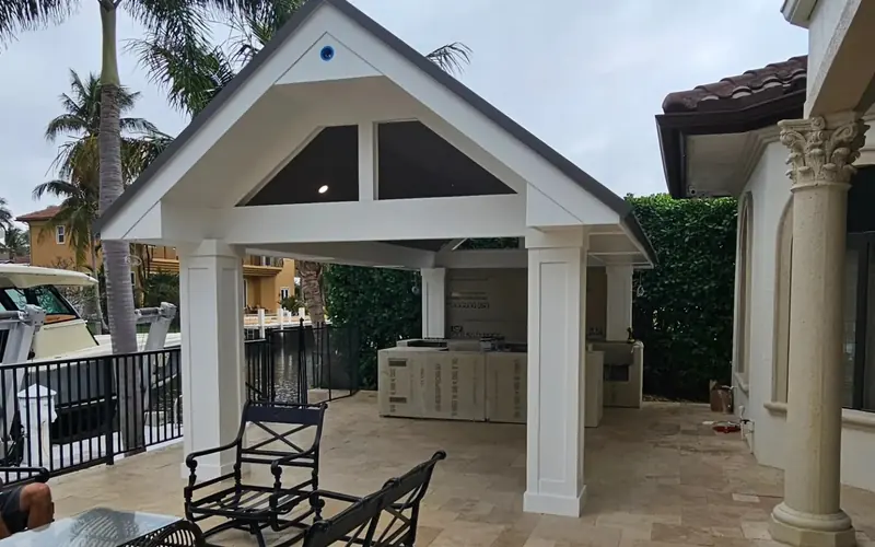Finished pavilion with white columns over a travertine patio