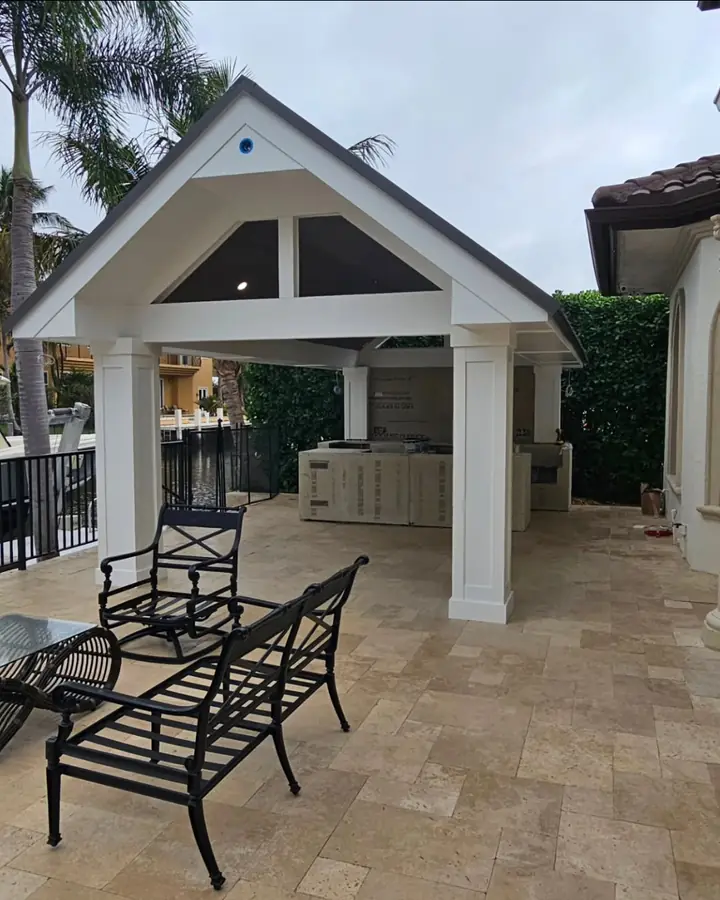 Outdoor pavilion with white columns over travertine pavers
