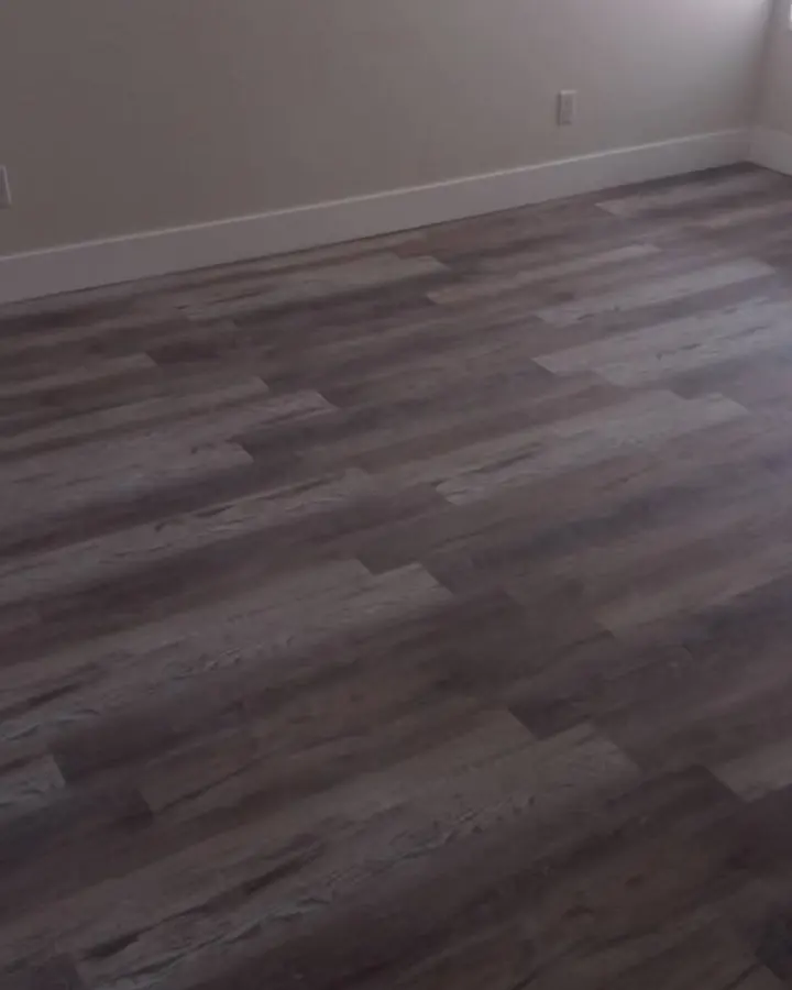Empty room with new grey wood-look plank flooring
