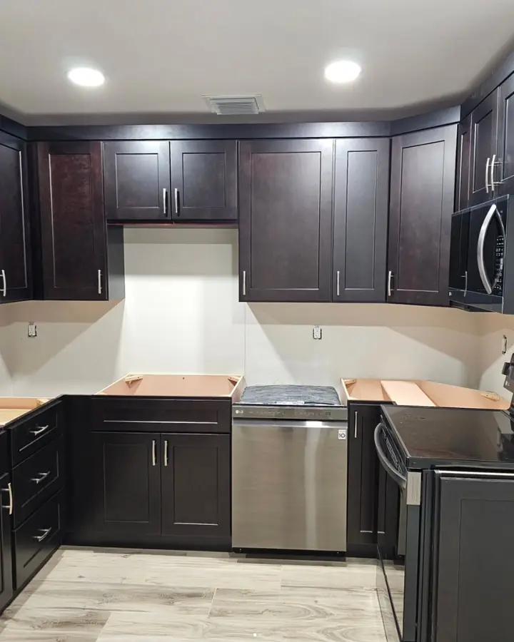 Kitchen with dark shaker cabinets installed, before the countertops go on