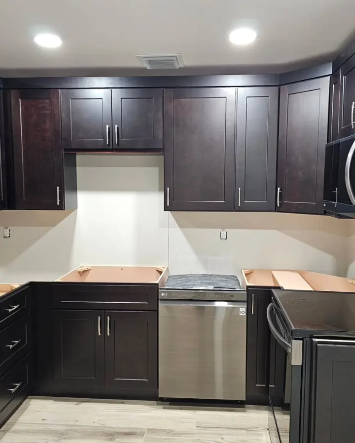 Kitchen with dark shaker cabinets installed, before the countertops go on