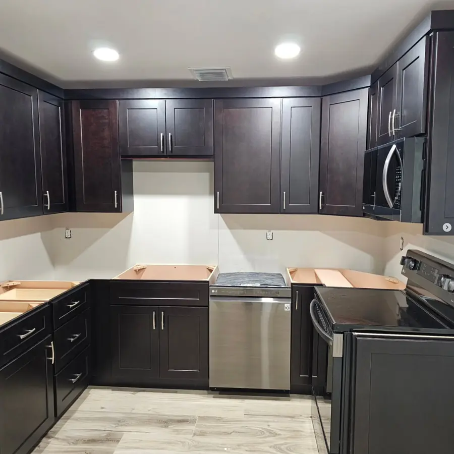 Kitchen with dark shaker cabinets installed, before the countertops go on