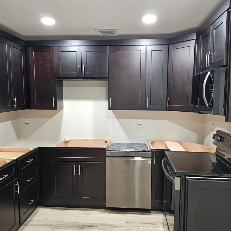 Kitchen with dark shaker cabinets installed, before the countertops go on