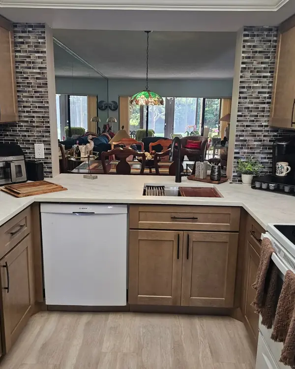Stained shaker kitchen with a sink run under a pass-through to the dining room